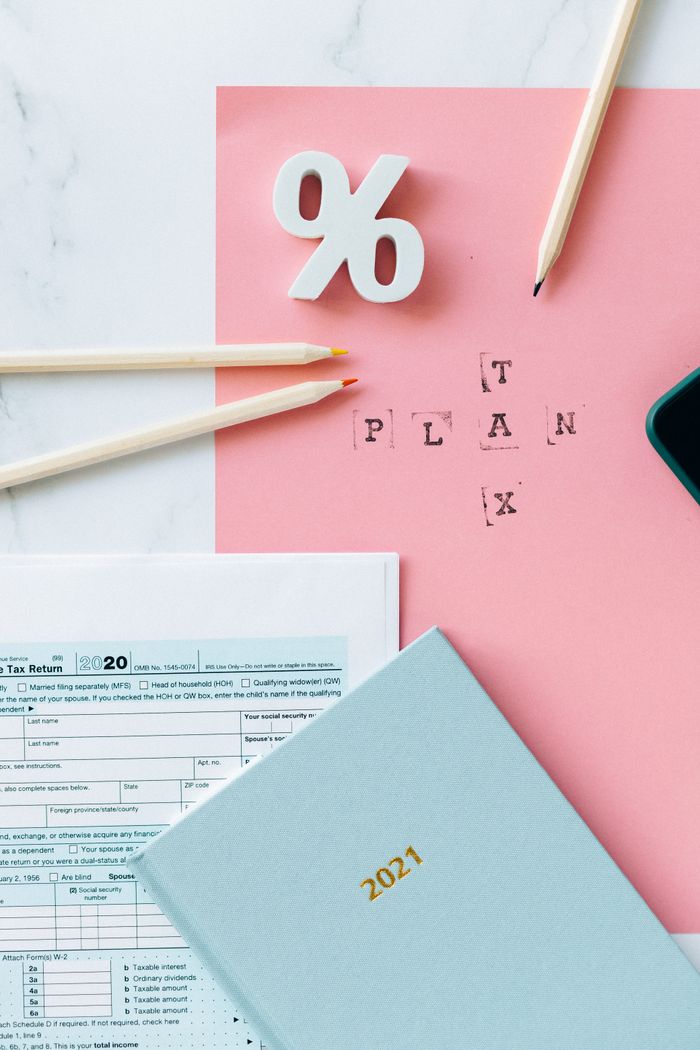 Flat lay of tax forms, calendar, and pencils illustrating tax planning.
